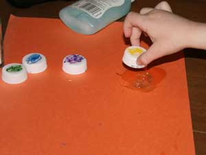kids making bottlecap caterpillar craft